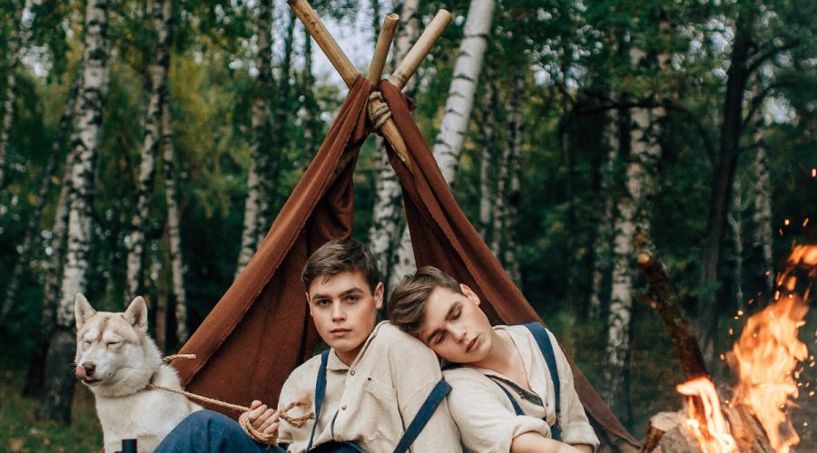 two boys and a dog camping with campfire