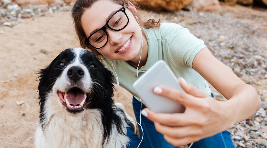 Girl Influencer with cell phone and her dog taking a selfie